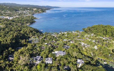 a aerial view of a town surrounded by trees and a body of water