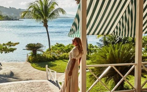 a woman standing on a porch by a body of water