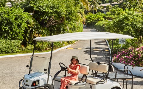 a woman driving a golf cart
