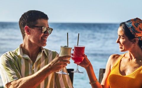 a man and woman sitting at a table with drinks
