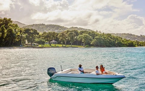 a group of people in a boat on water with trees in the background