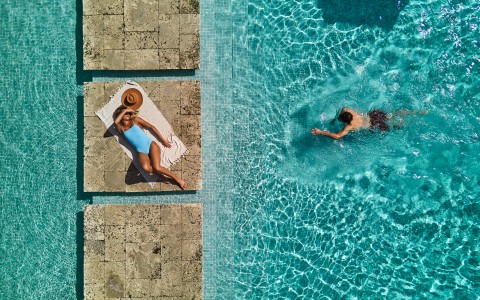 a woman lying on a towel in a pool