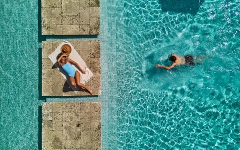 a woman lying on a towel in a pool