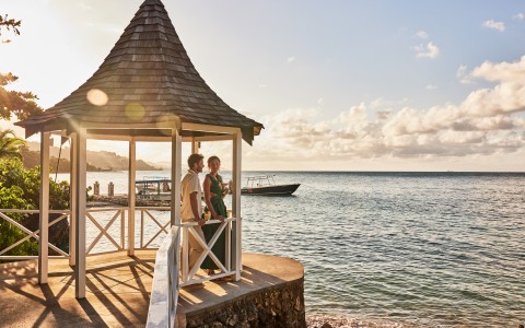 a man and woman standing on a deck overlooking a body of water