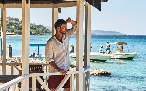a man standing in a gazebo by the water