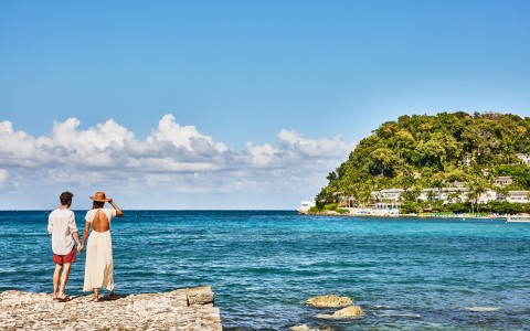 a woman standing on a dock looking at the ocean