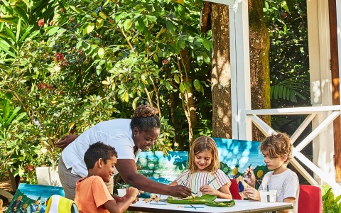 a group of kids sitting at a table outside