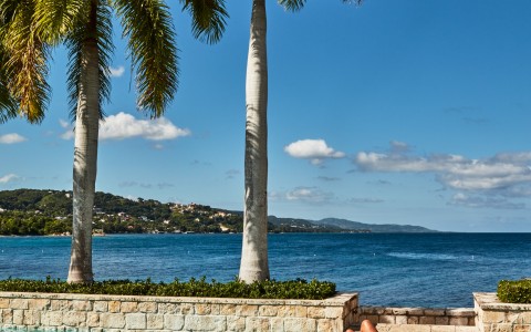 a woman lying on a pool next to a body of water