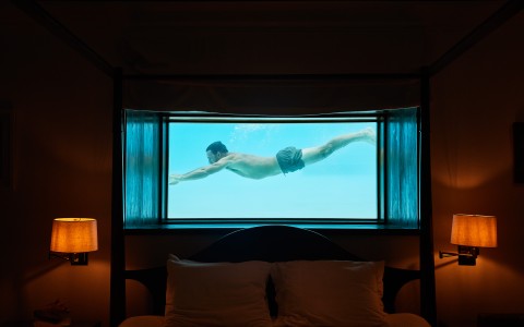 a man swimming underwater in a bed