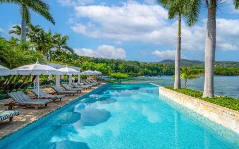 a pool with lounge chairs and umbrellas