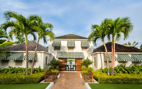 a building with palm trees and a bench