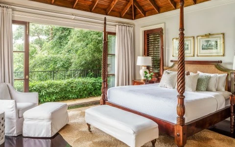 a bedroom with a four poster bed and a bench