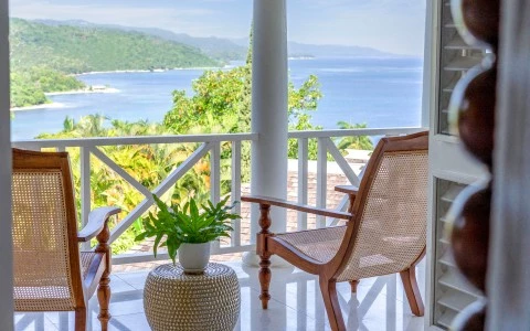 a chair and table on a porch overlooking a body of water