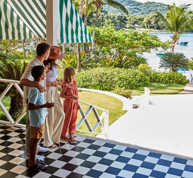 a group of people standing on a porch looking at a lake
