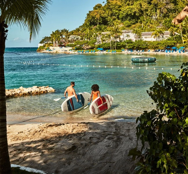 a couple of people with surfboards in the water