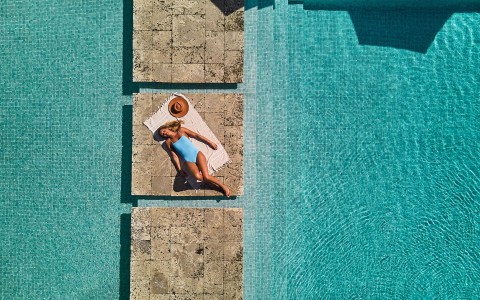 a woman lying on a towel in a pool