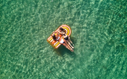 a group of women floating on an inflatable raft in the water