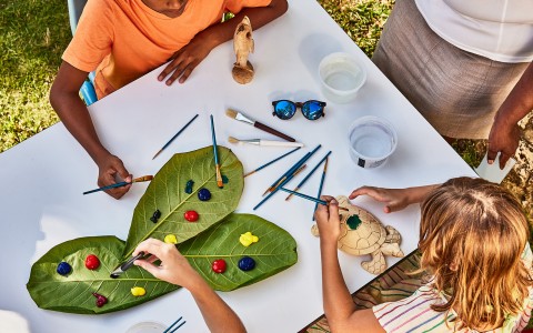 a group of kids painting on leaves