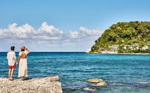 a body of water with a building and trees in the background