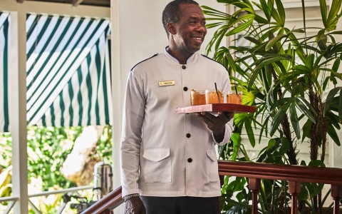 a man holding a tray of drinks