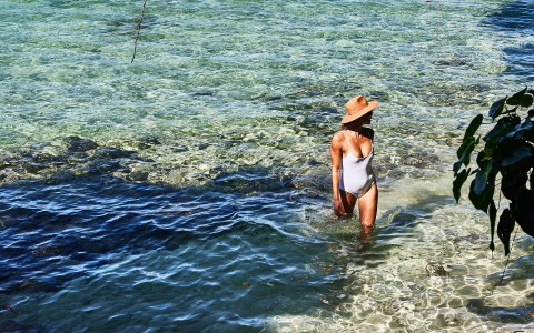 a woman in a swimsuit standing in water