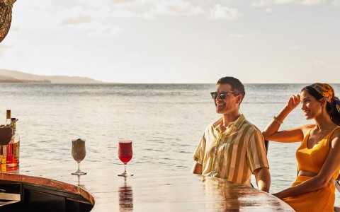 a man sitting at a table with drinks on it