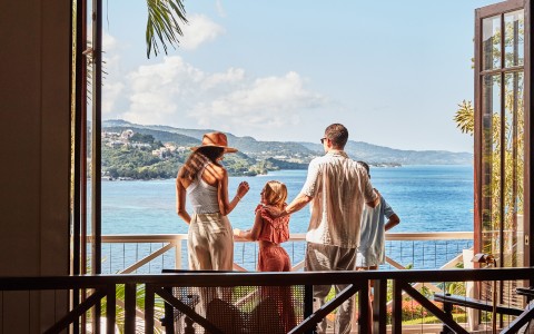 a group of people standing on a balcony overlooking a body of water