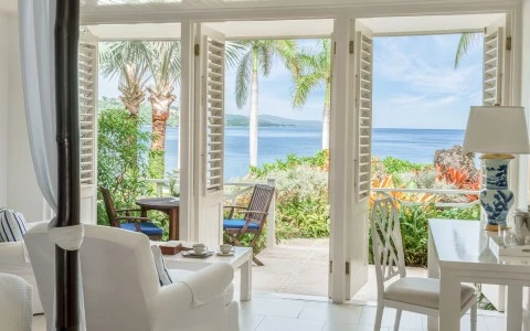 a room with white furniture and a view of the ocean