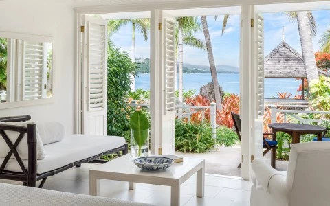 a room with white furniture and a view of the ocean