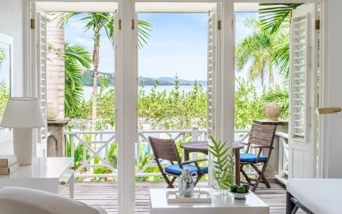 a patio with a view of the ocean and trees