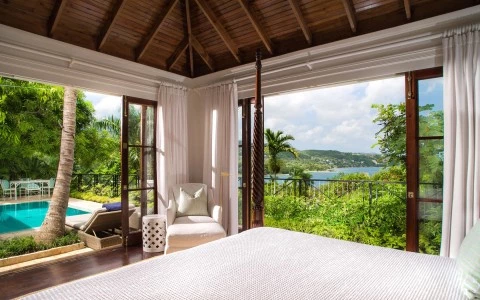 a room with a bed and a view of the water
