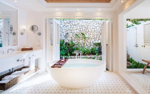 a white bathroom with a tub and a white tile floor