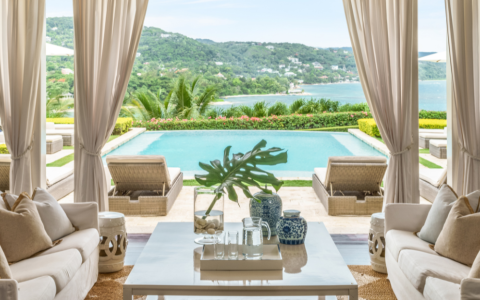 a living room with a pool and a view of the water