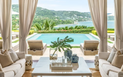 a living room with a pool and a view of the water