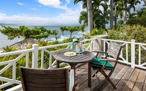 a table and chairs on a deck overlooking a body of water