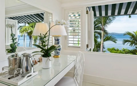 a white table with a lamp and a plant on it