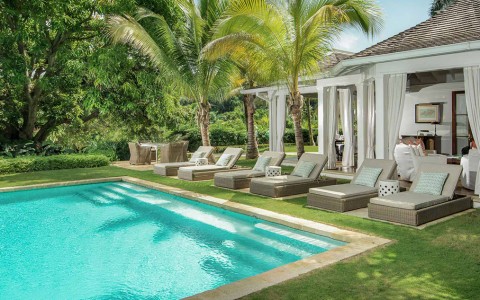a pool with lounge chairs and palm trees