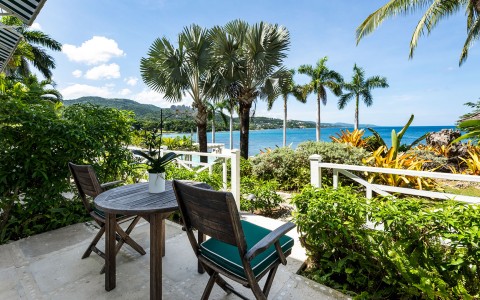 chairs and chairs on a patio overlooking a body of water