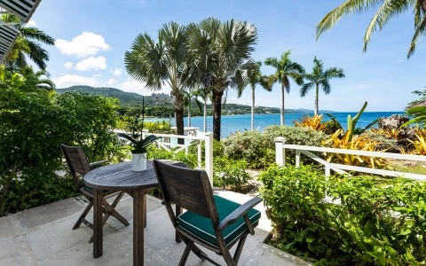 chairs and chairs on a patio overlooking a body of water