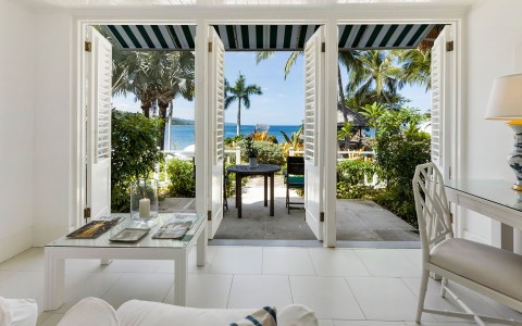 a room with a view of the ocean and a table and chairs