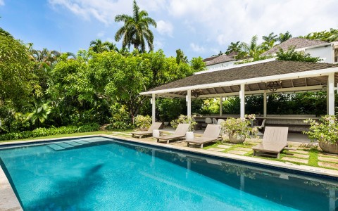 a pool with lounge chairs and a gazebo