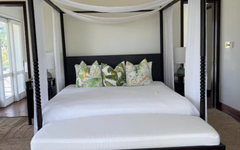 a bed with white sheets and pillows
