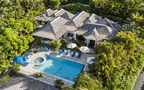 a swimming pool and a house with trees around it