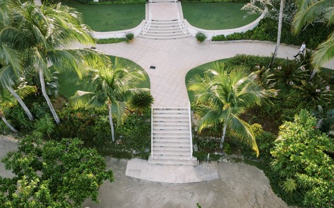 a building with a walkway and palm trees