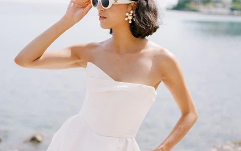 a woman in a white dress and sunglasses