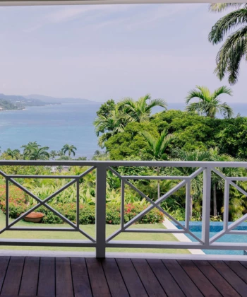 a deck with a view of the ocean and trees