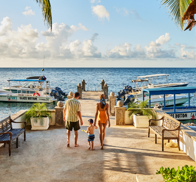a family walking on a dock with boats in the water