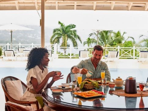 a man and woman sitting at a table with food on it