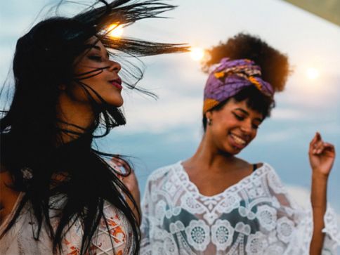 a couple of women standing on a beach