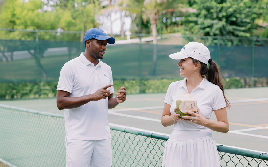 a man and woman standing on a tennis court